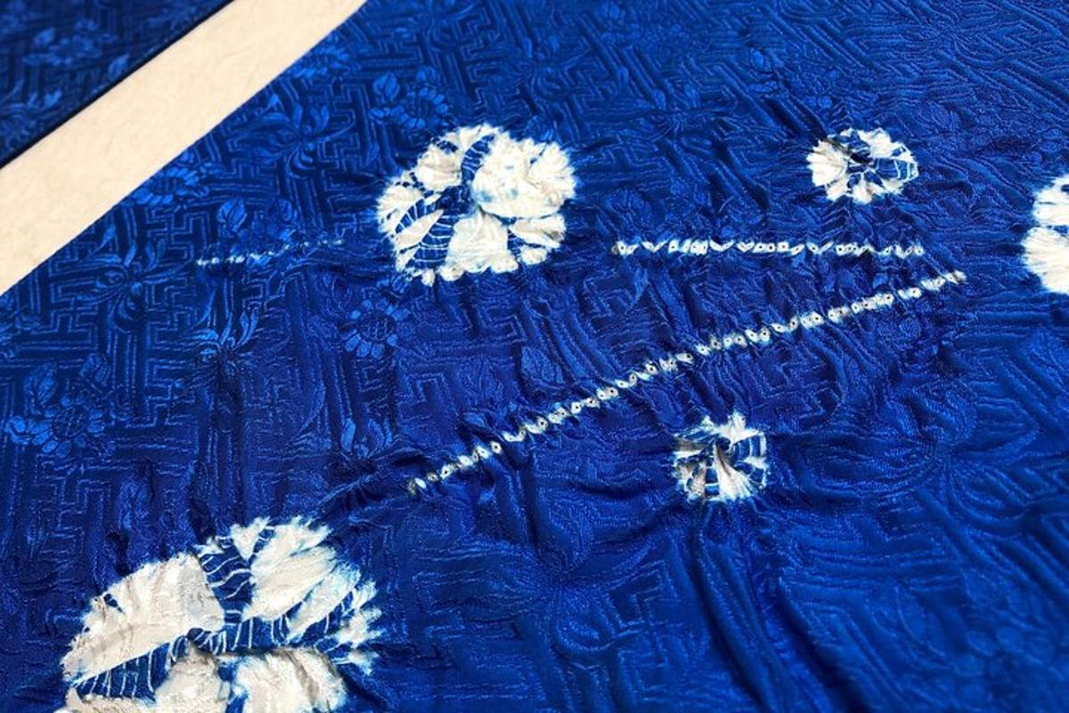 una coperta blu con fiori bianchi sopra