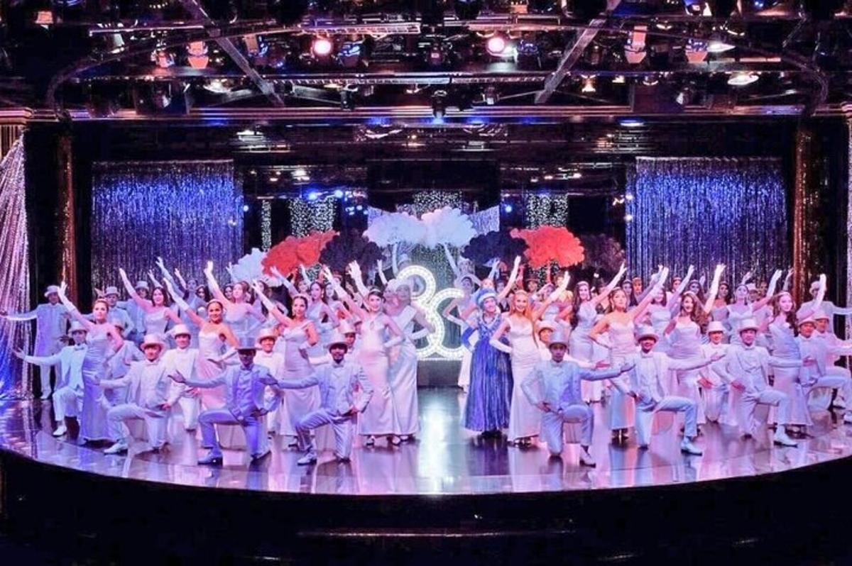 a group of people on a stage with their hands in the air