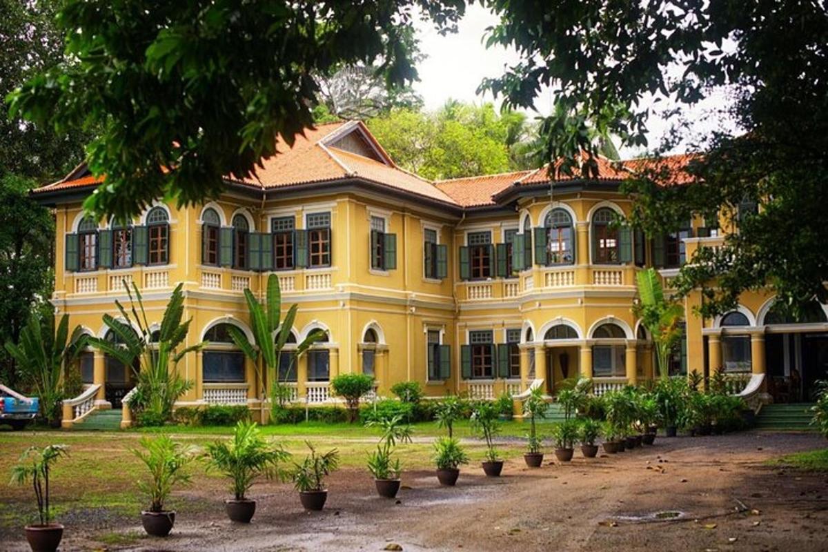 sebuah bangunan besar berwarna kuning dengan pokok-pokok di hadapannya
