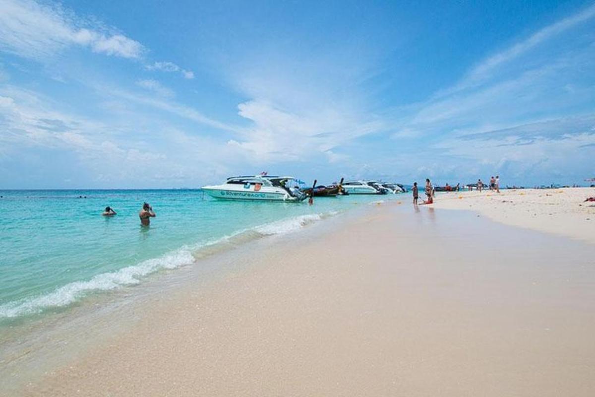 ljudje na plaži s čolni v vodi
