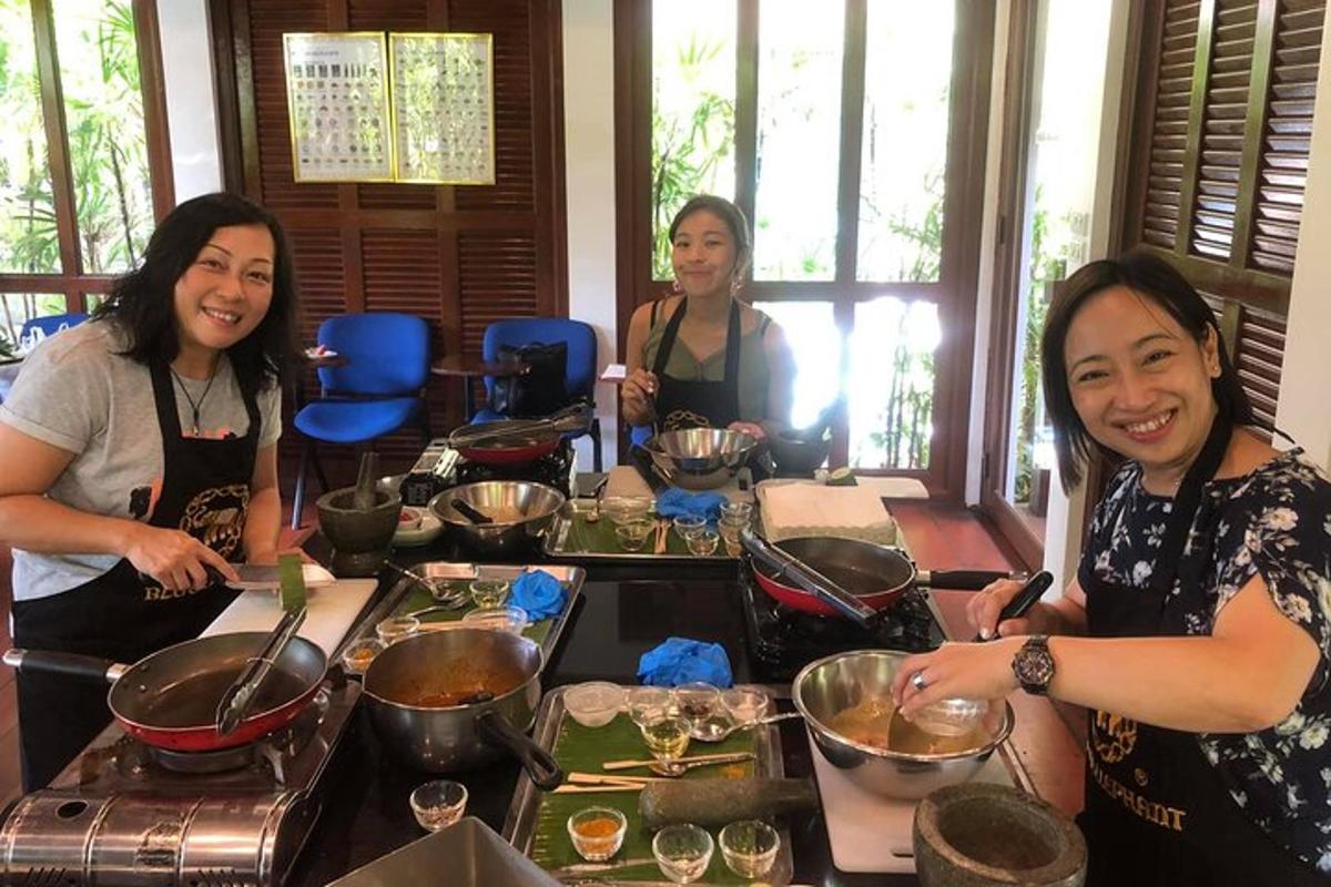 một nhóm phụ nữ đứng quanh bàn chuẩn bị thức ăn