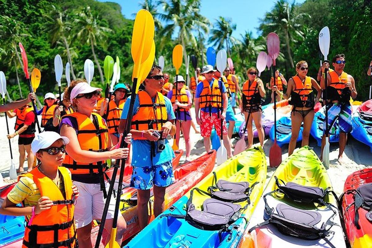sekumpulan orang berdiri di pantai dengan kayak