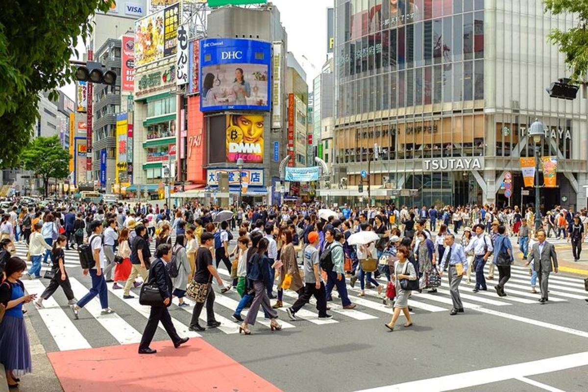 uma grande multidão de pessoas atravessando uma rua movimentada da cidade