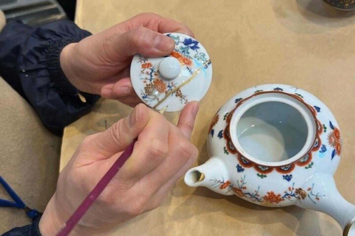 a person holding a teapot and a cup of coffee