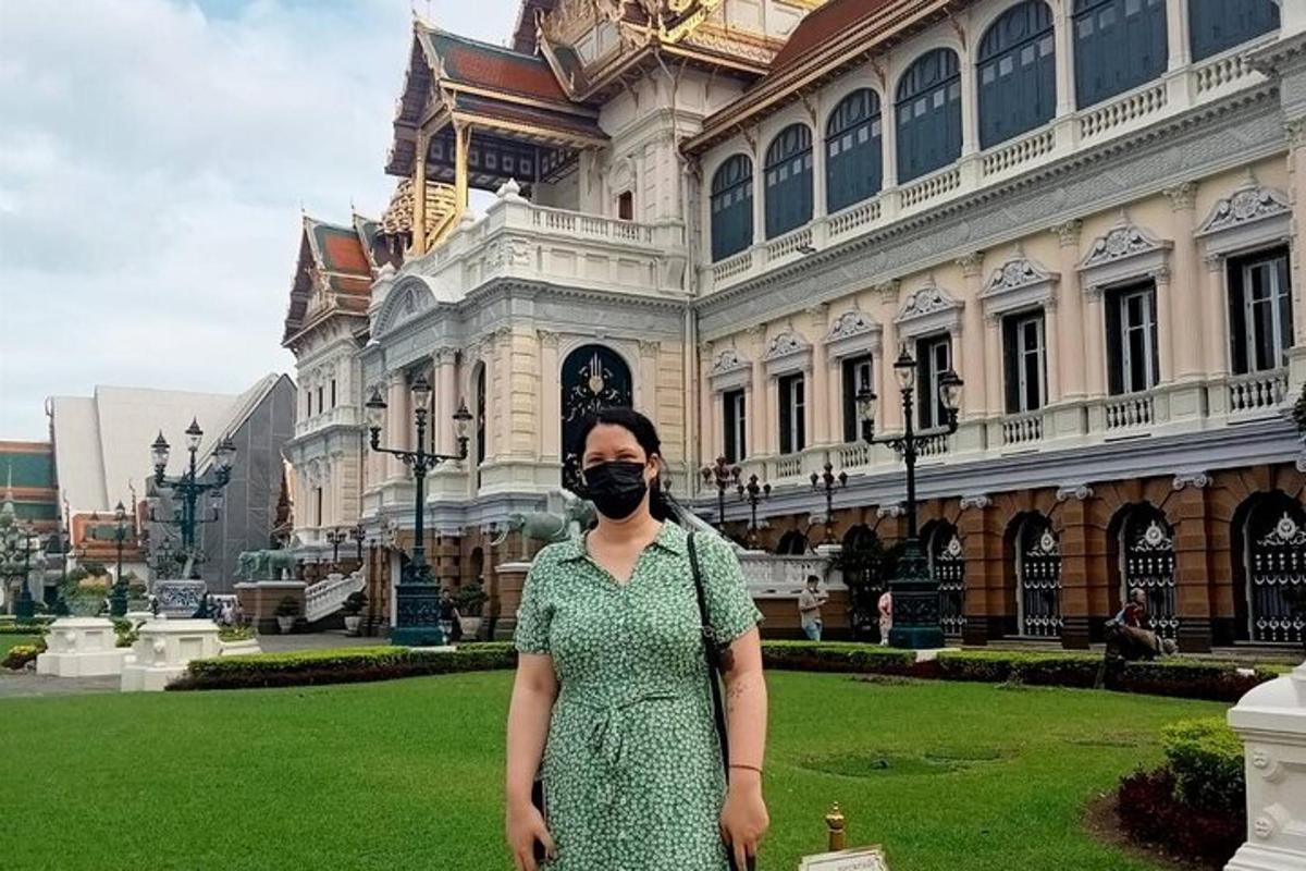 ผู้หญิงสวมหน้ากากอยู่หน้าอาคาร