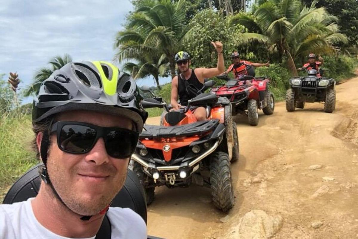 um grupo de pessoas andando de quadriciclo em uma estrada de terra