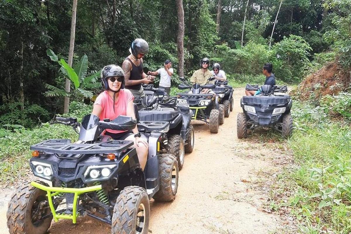en gruppe mennesker som kjører ATV på en grusvei