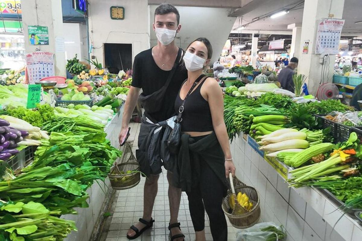 un bărbat și o femeie purtând măști de față într-o piață