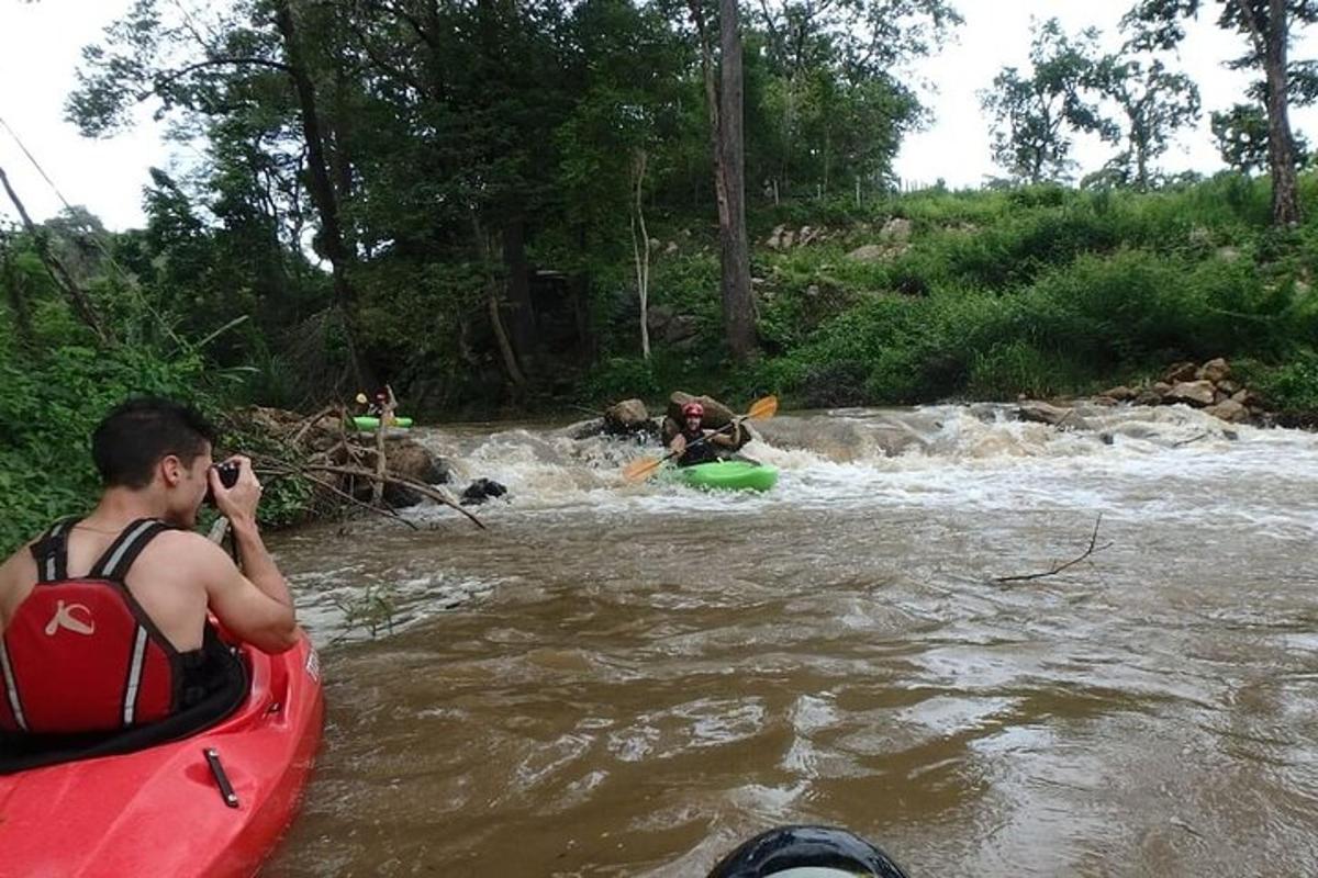um homem tirando uma foto de pessoas em uma jangada em um rio