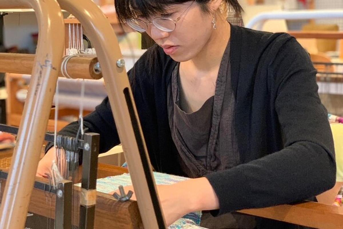 a woman sitting at a table working on a machine