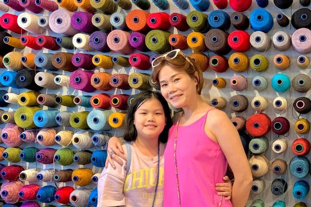 a woman and a little girl standing in front of a wall of hats