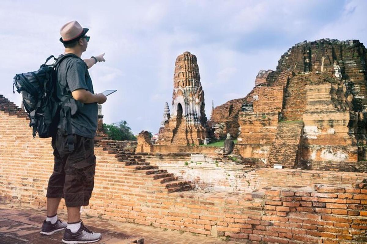 un home dret sobre una paret de maons assenyalant un temple