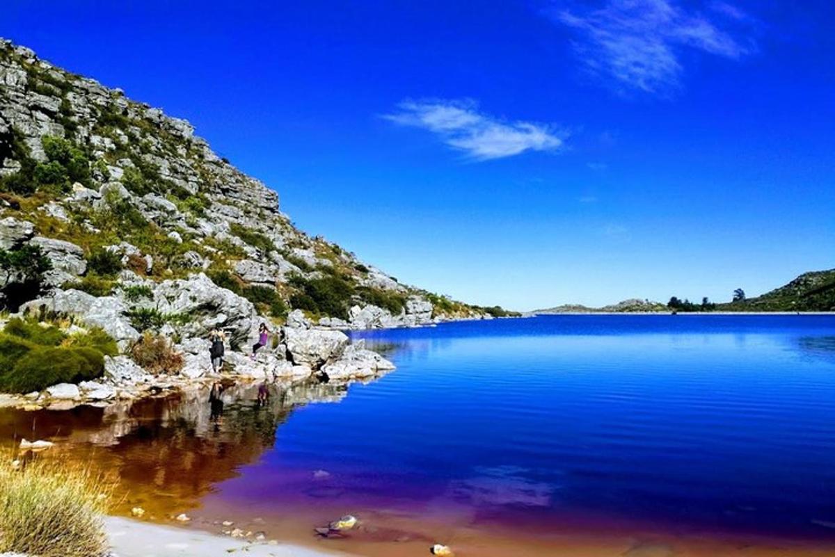 a large body of blue water next to a mountain