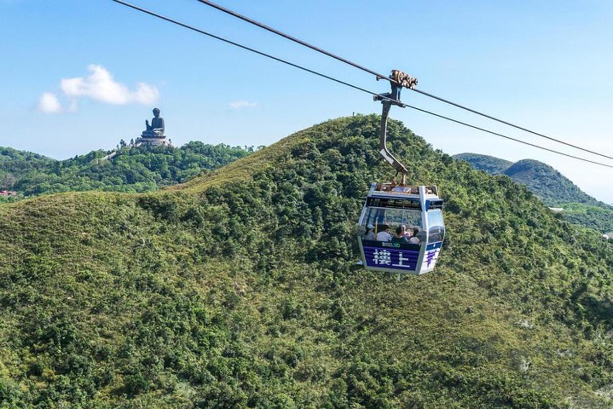 lanovka letící nad kopcem se sochou