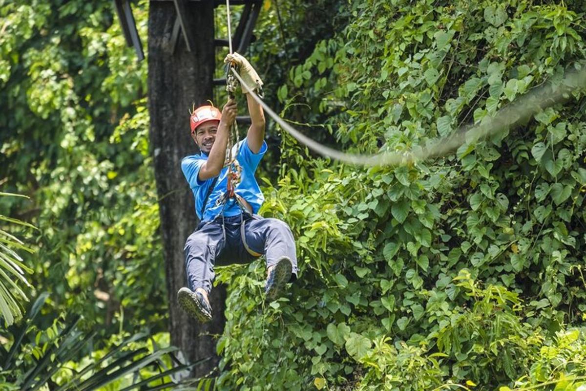 un home penjat d'una corda a la selva