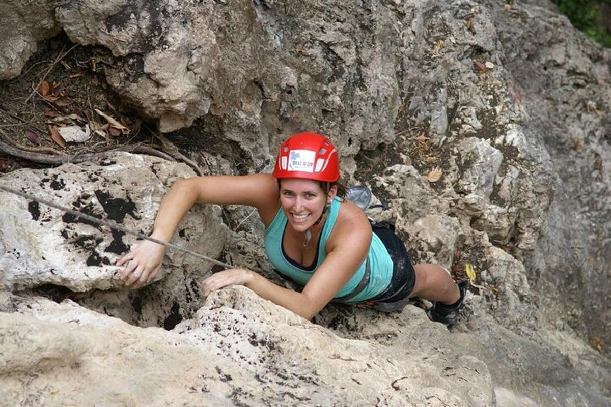 una dona amb un barret vermell estirada sobre una roca
