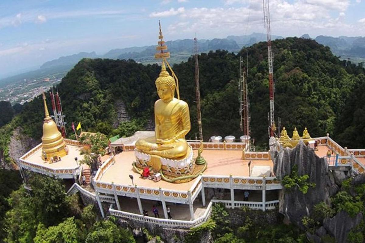 un grande edificio con una grande statua dorata in cima