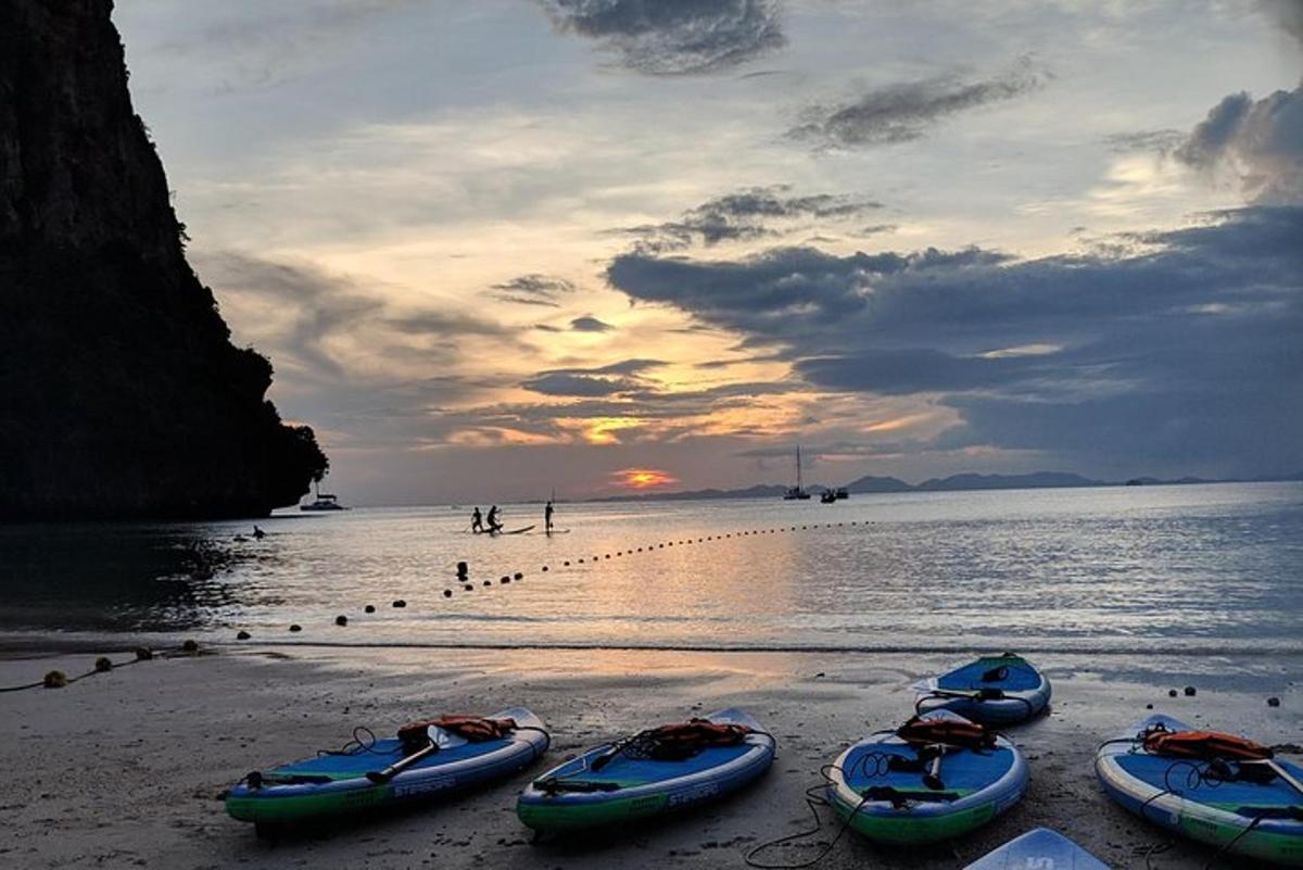un gruppo di barche su una spiaggia al tramonto