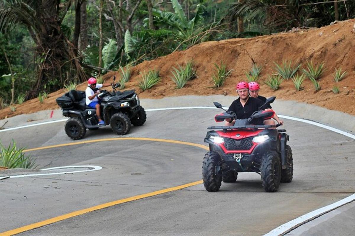 two people on atvs driving down a road