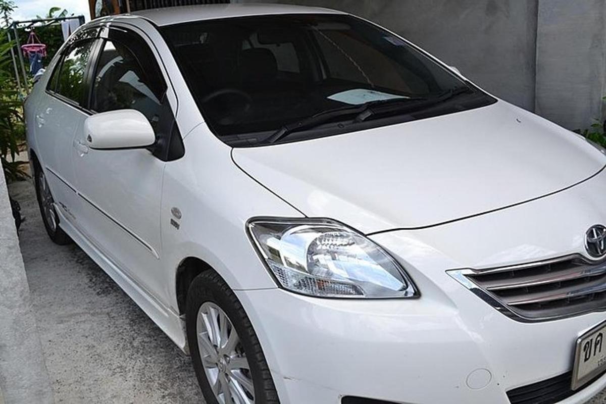 ein weißes Auto, das neben einem Gebäude geparkt ist