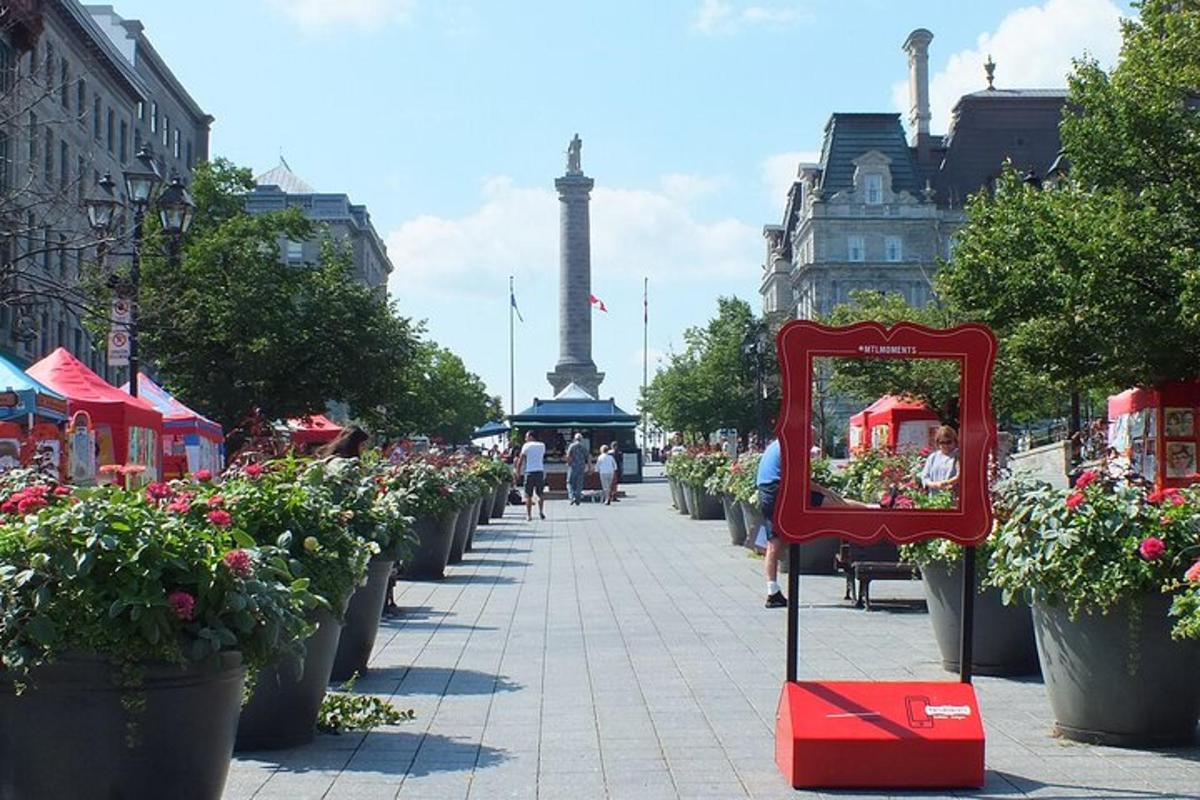 una strada con fiori e un cartello sul marciapiede