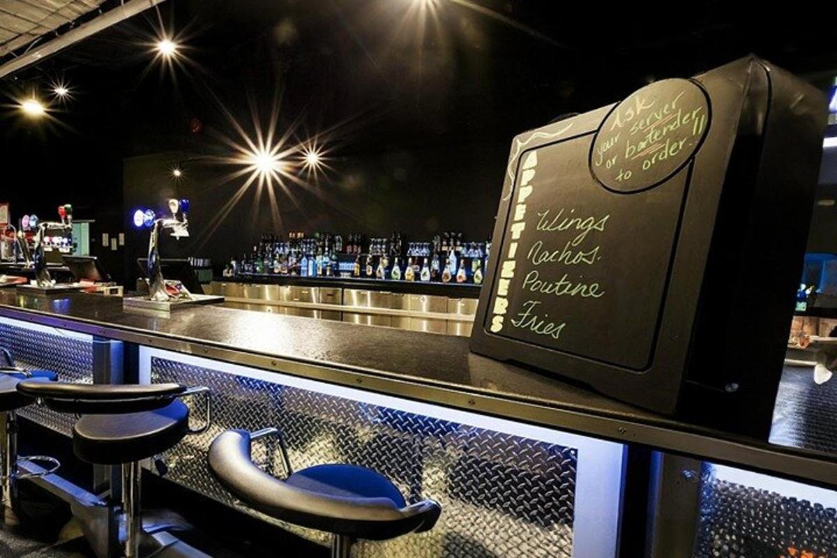a bar with stools at a bar with bottles of alcohol