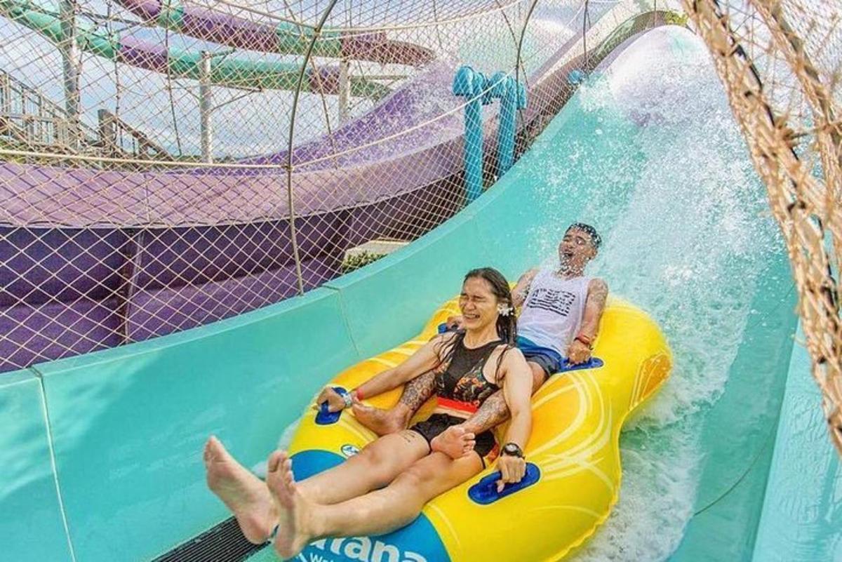 two people riding on a water slide at a water park