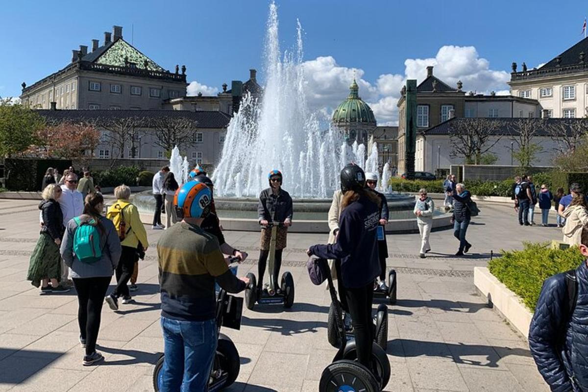 en gruppe mennesker som står foran en fontene