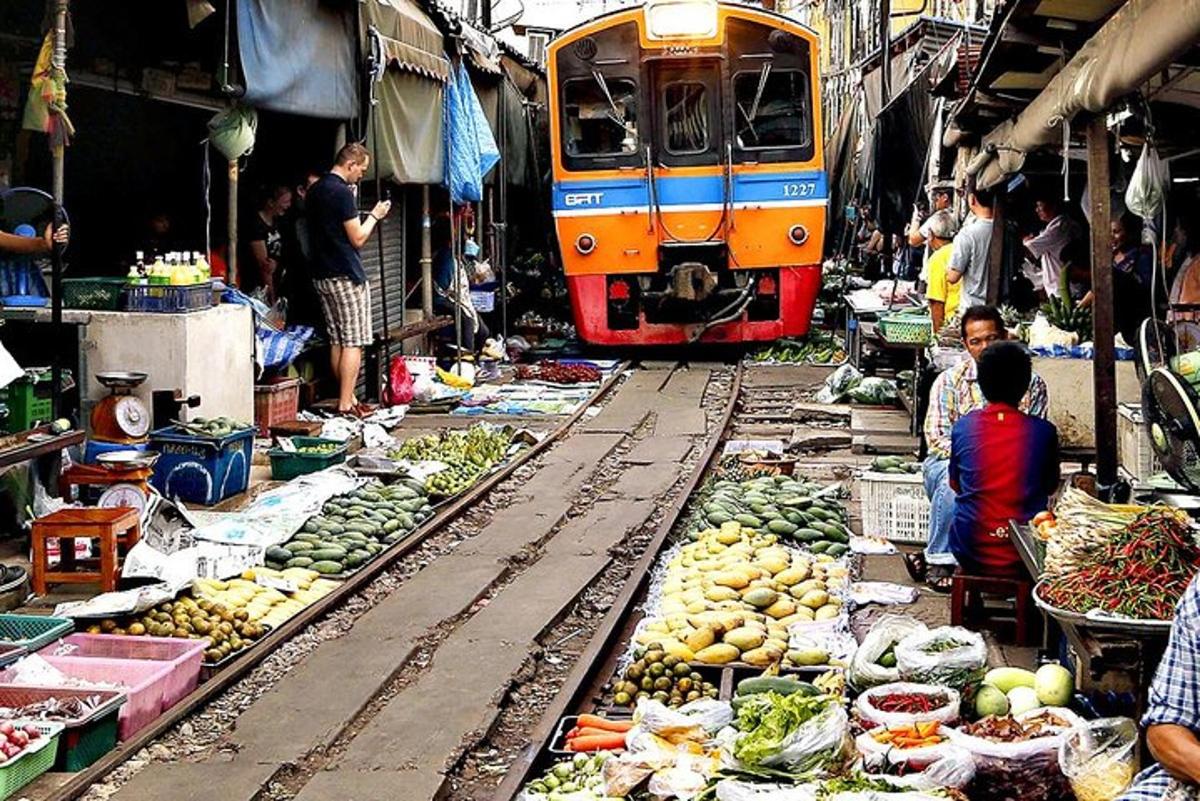 một chuyến tàu chạy qua một khu chợ bán trái cây và rau quả