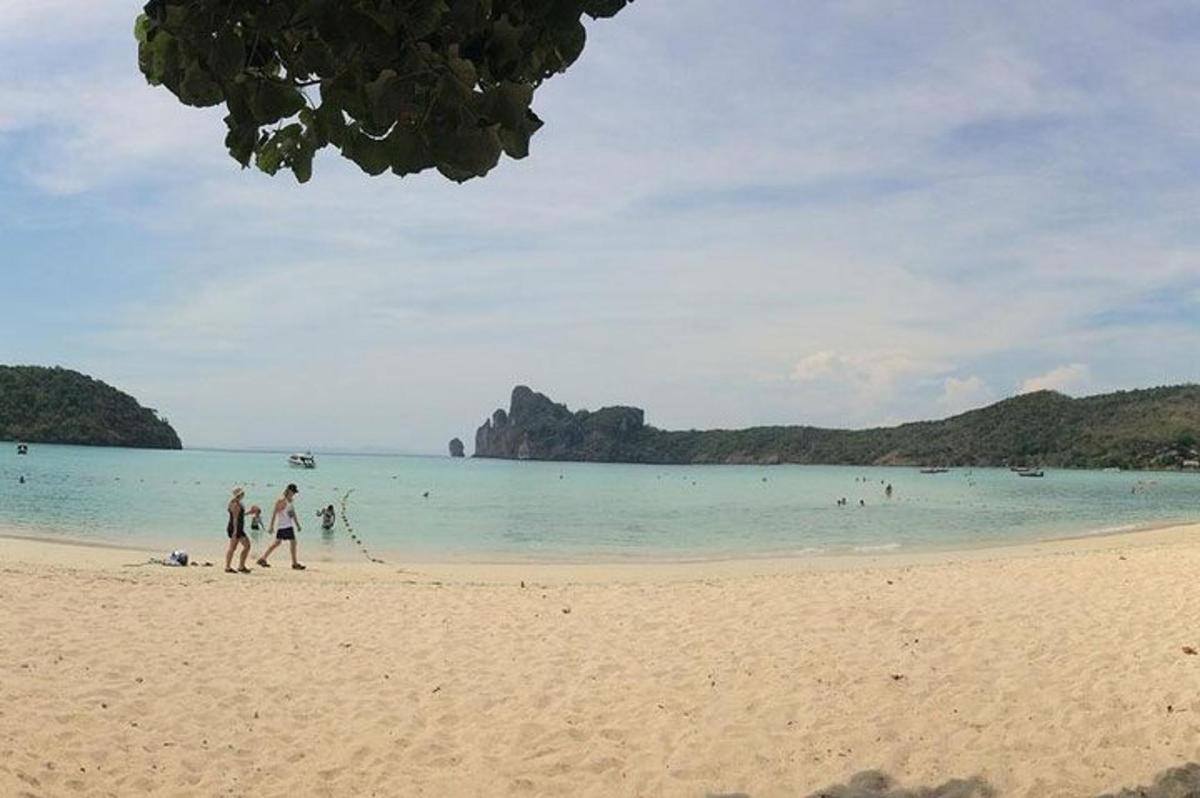 dua orang berjalan di pantai berhampiran air