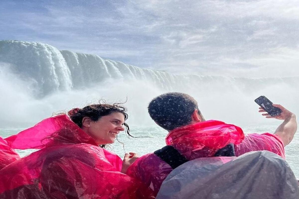 a man and a woman in pink life jackets in front of a waterfall