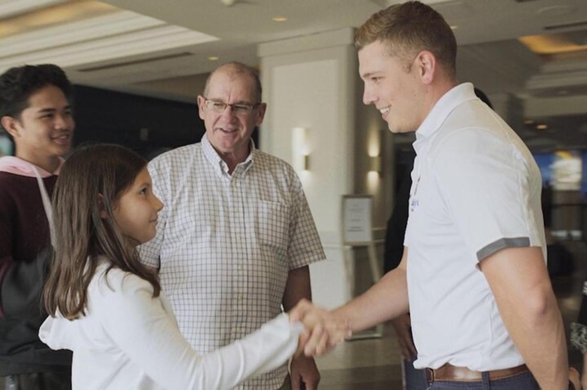 a young girl is shaking hands with a man