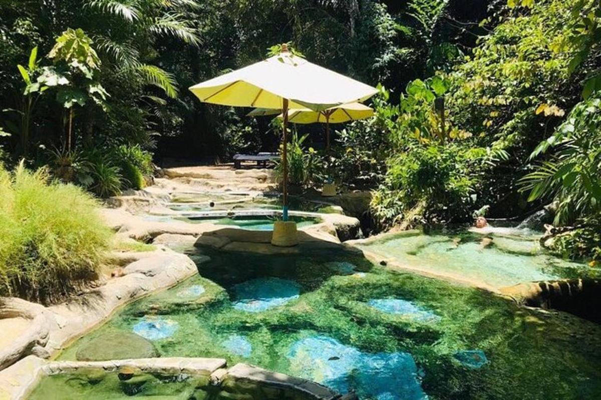 una piscina amb un para-sol i una mica d'aigua