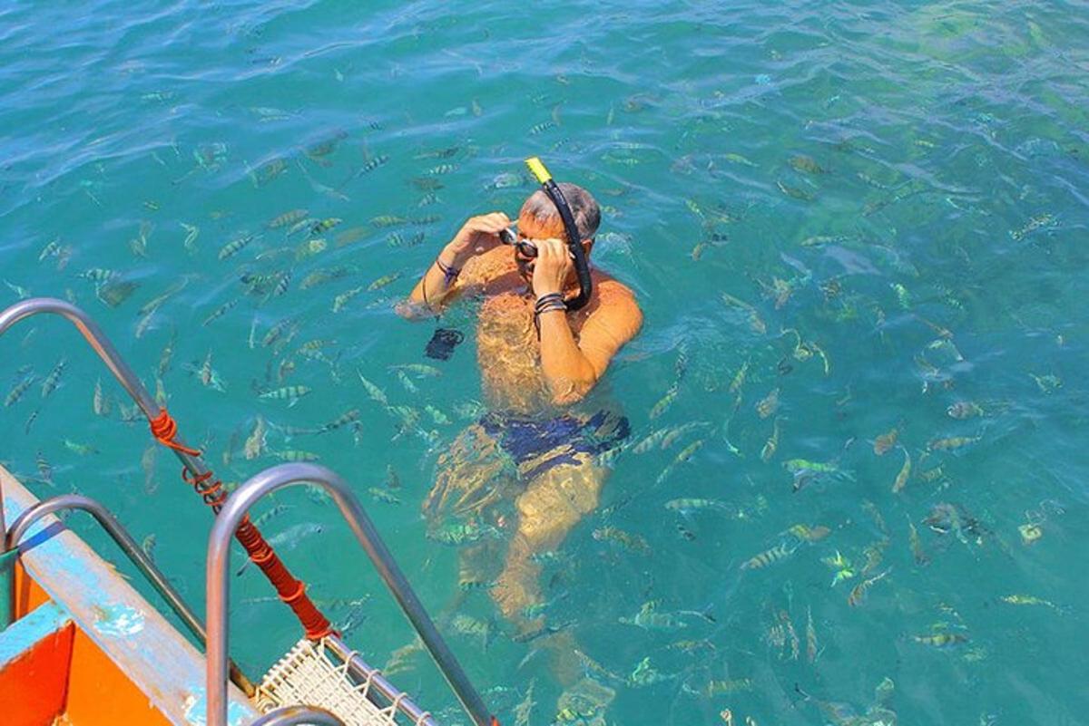 a person in the water taking a picture of fish