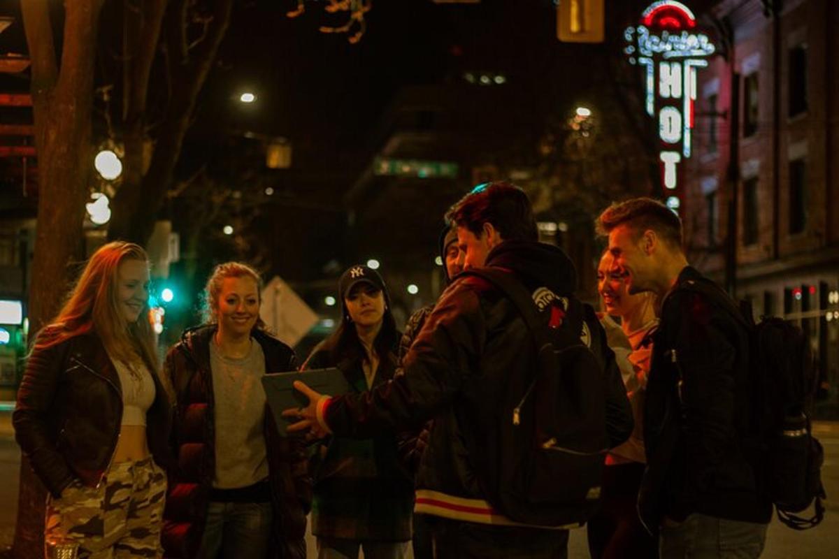 un gruppo di persone in piedi su una strada di notte