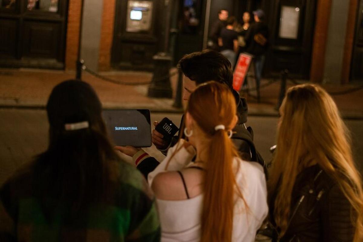 un gruppo di persone in piedi con i loro cellulari