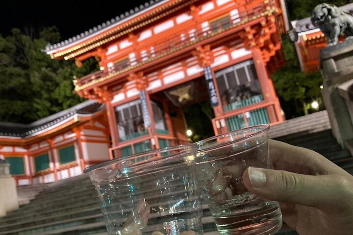 una persona che tiene in mano un bicchiere d'acqua davanti a un edificio