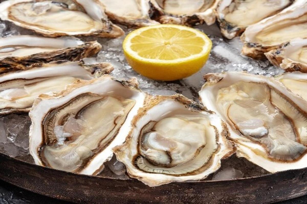 a bunch of oysters in a pan with a lemon