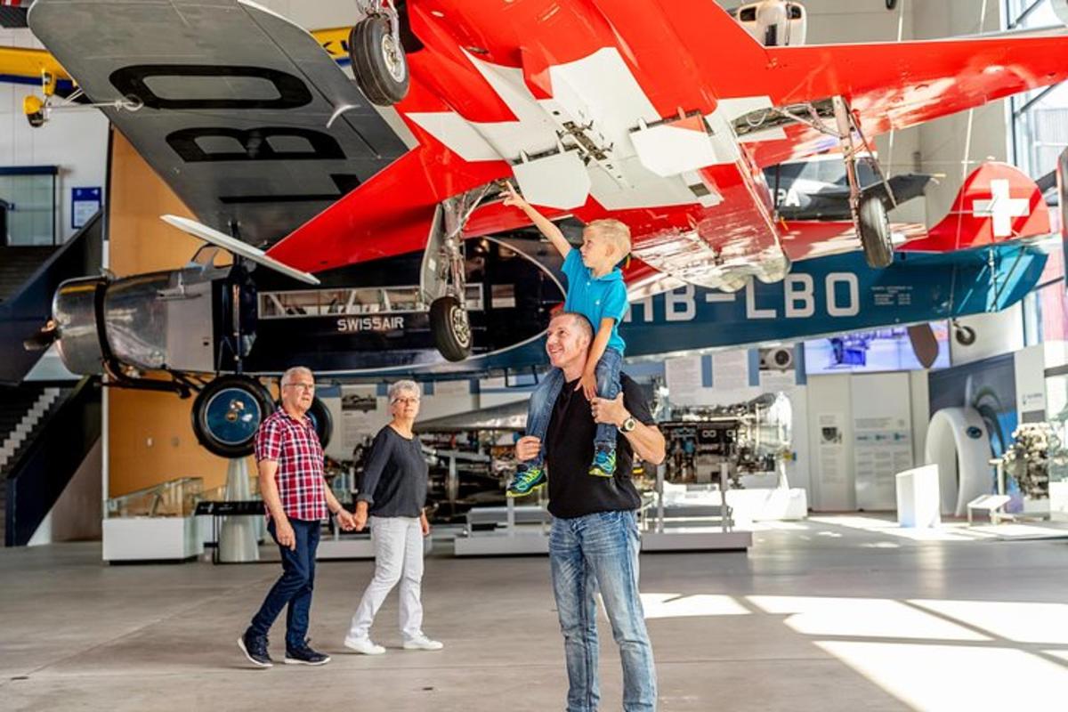 a man holding a child on his shoulders in front of an airplane