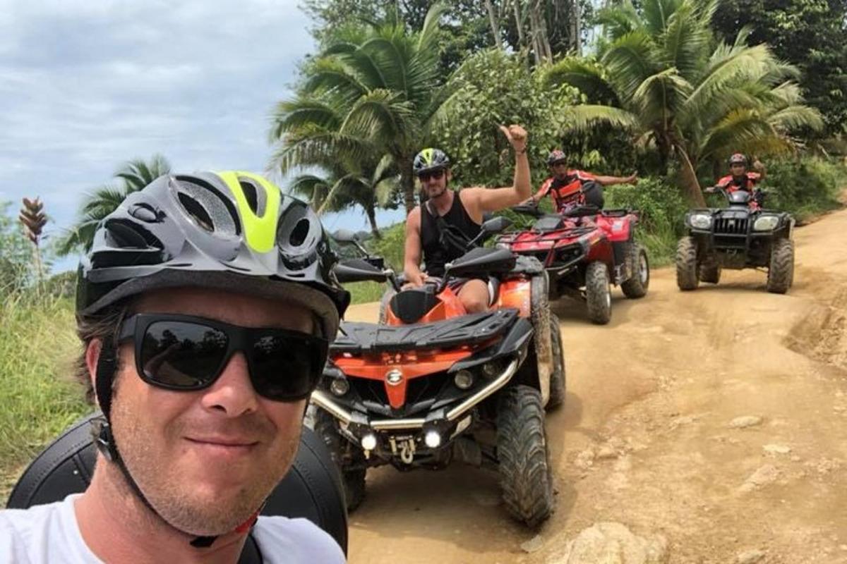 a group of people riding atvs on a dirt road