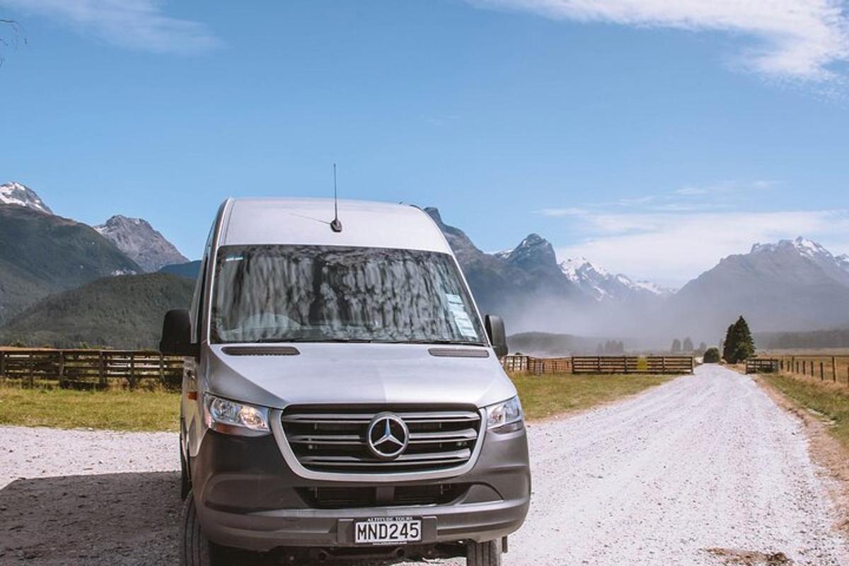 a van parked on a dirt road with mountains in the background