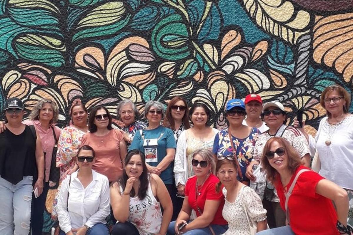 a group of people posing in front of a mural