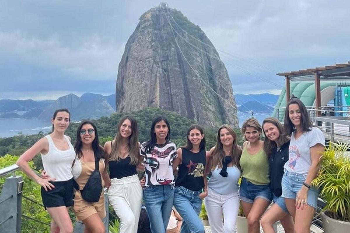 a group of women posing in front of a rock