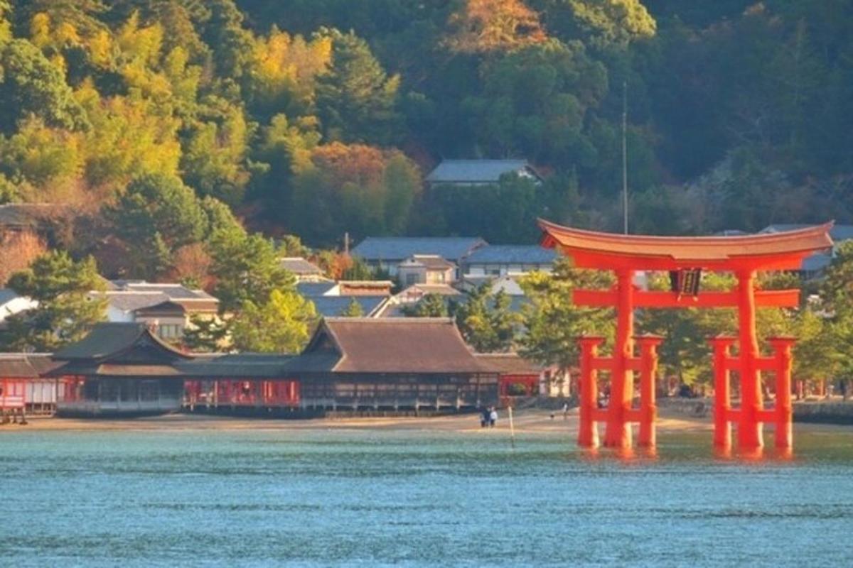 an orange gate in the water in front of a building