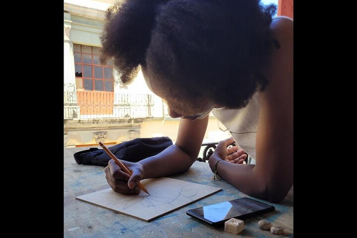 a young boy writing on a piece of paper with a pencil