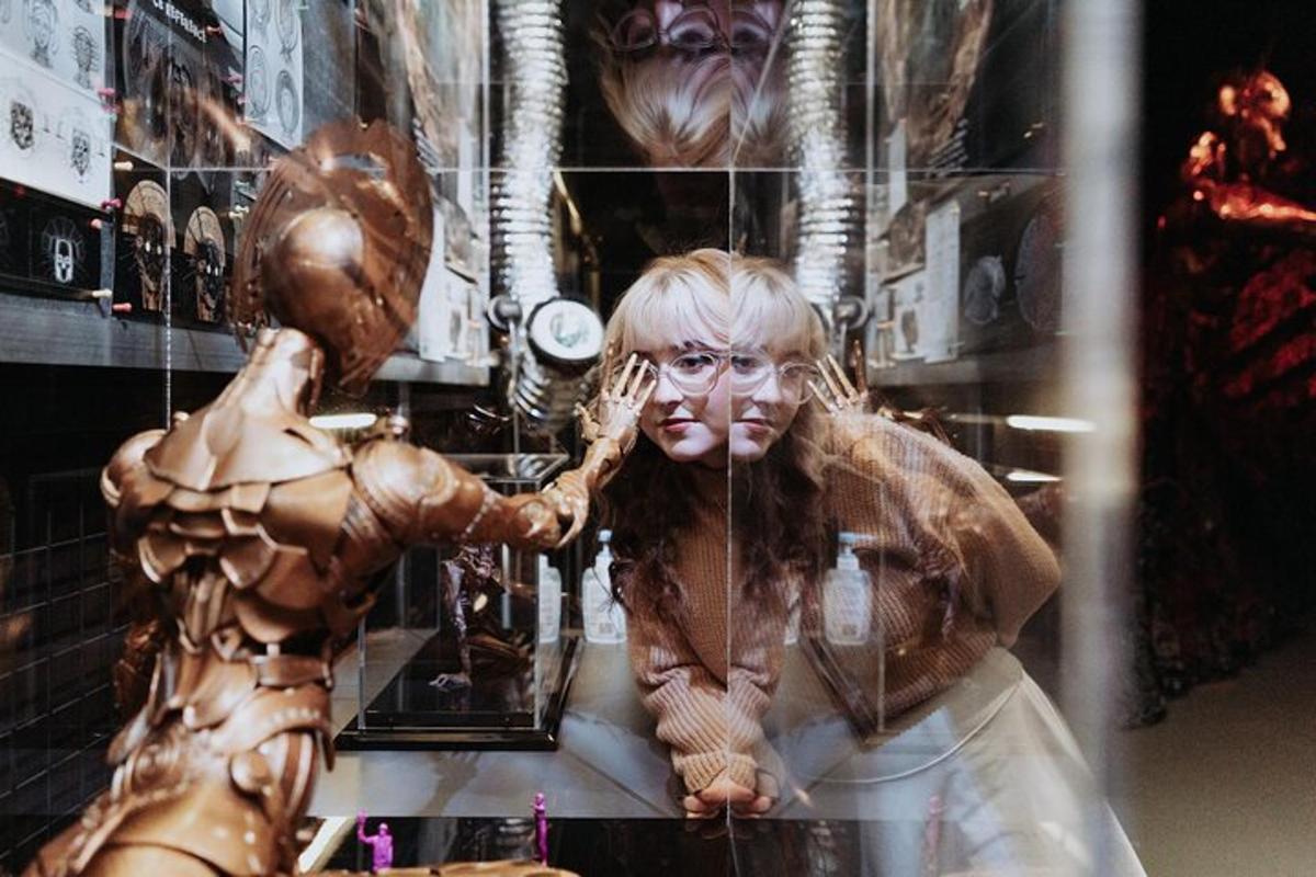 a woman standing next to a mannequin in a store window