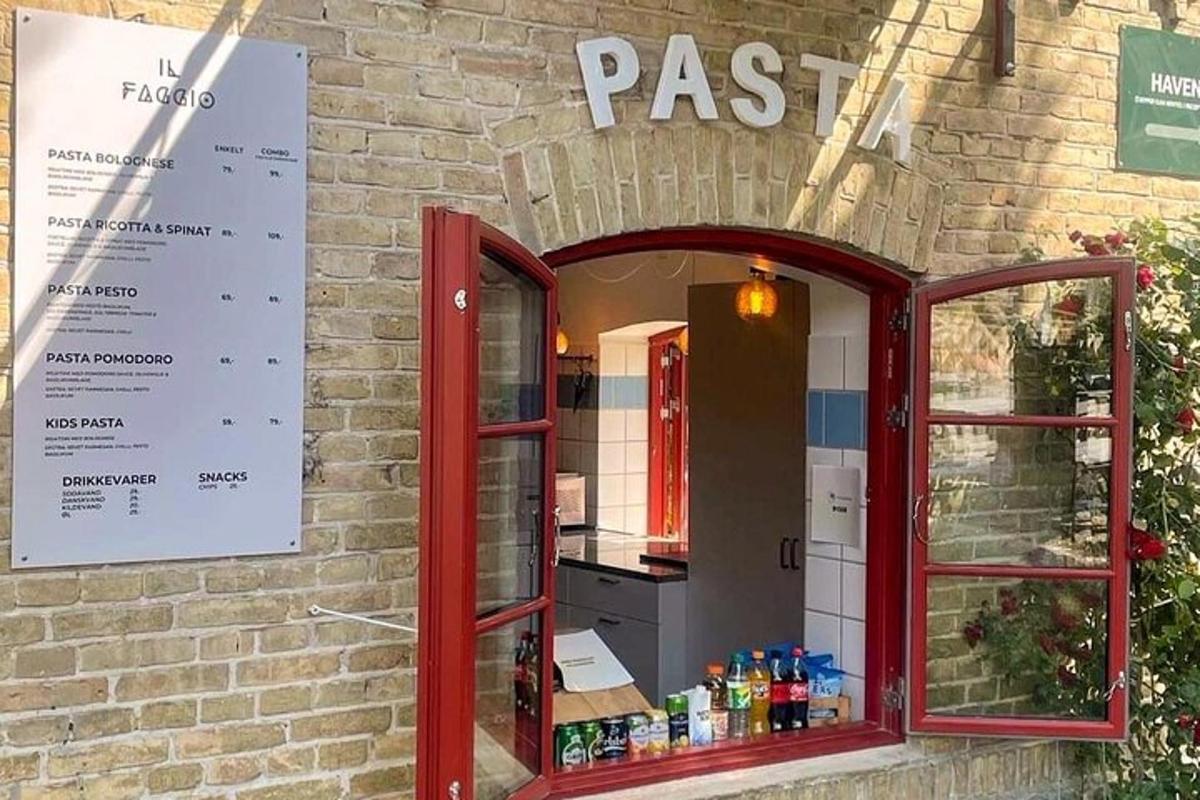 ένα κόκκινο παράθυρο σε ένα κτίριο από τούβλα με ένα εστιατόριο