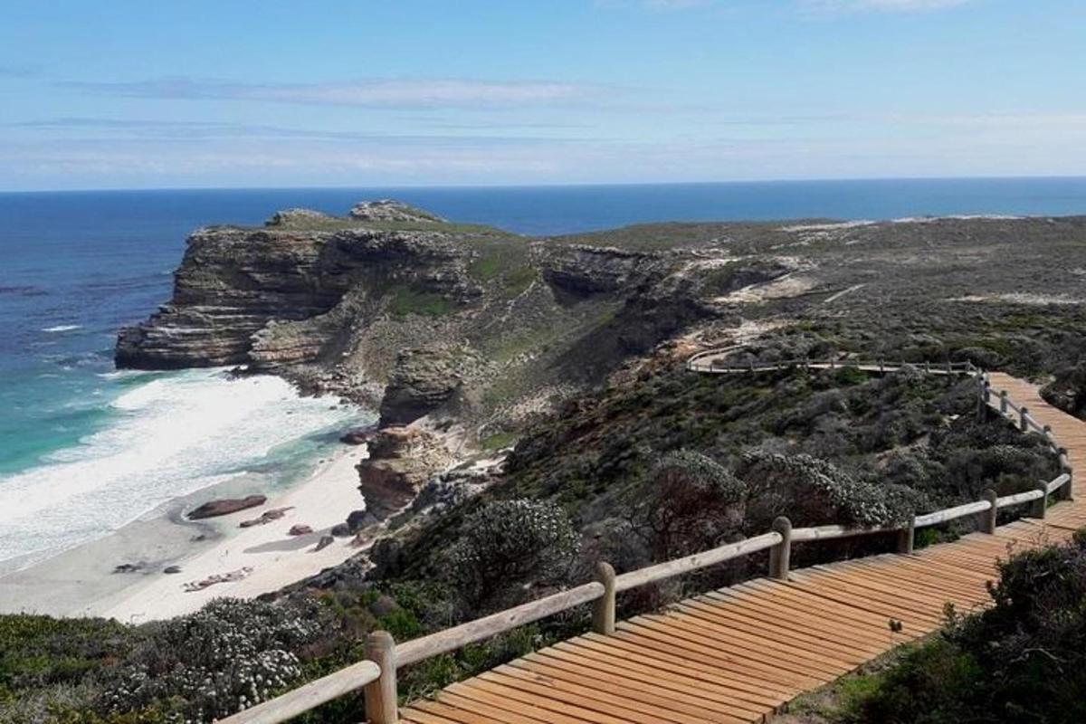 Una escalera de madera que conduce a una playa con el océano.