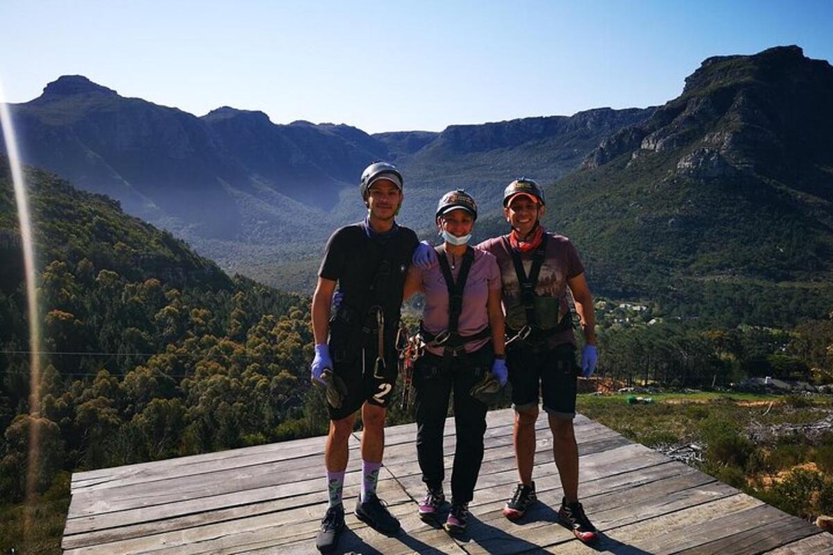 tre persone posano per una foto in cima a una montagna