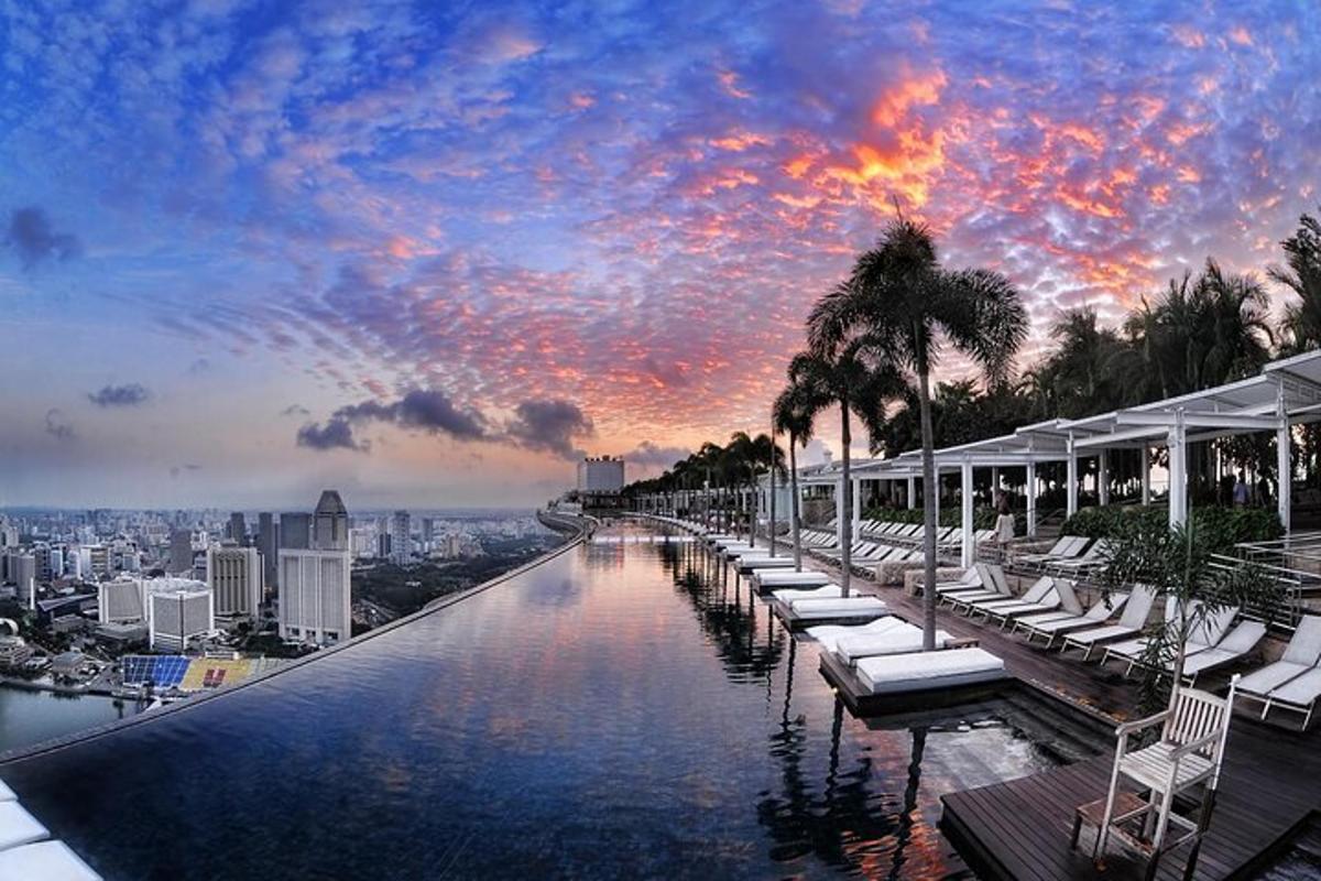 a pool with lounge chairs and a view of a city